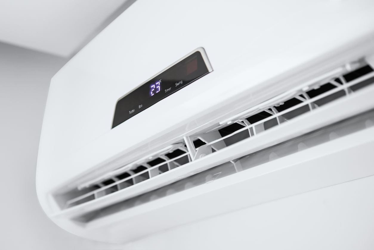 Promoções Black Friday: ar-condicionado branco modelo split, instalado no alto da parede branca, mostra o visor digital marcando 23°C