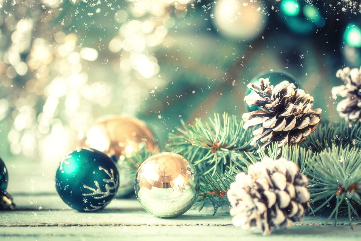 Enfeites de Natal: bolas verdes e douradas decoradas ao lado de galhos de árvore de Natal