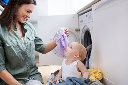 Máquina de Lavar - Encontre a Lavadora perfeita para você Máquina de Lavar - Mulher com filho em frente a máquina de lavar