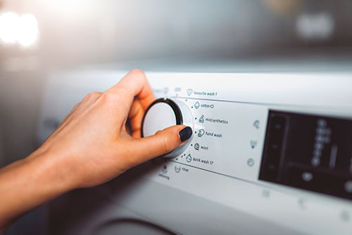 Máquina de Lavar - Pessoa selecionando a função da lavadora